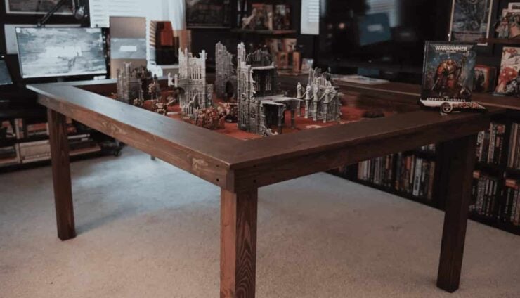 gaming table warhammer 40k in a room with terrain set up and books on shelves