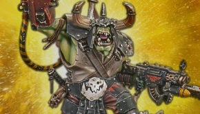 new ork warboss model painted claw in air with twin slugga starburst explosion bakground warhammer 40k